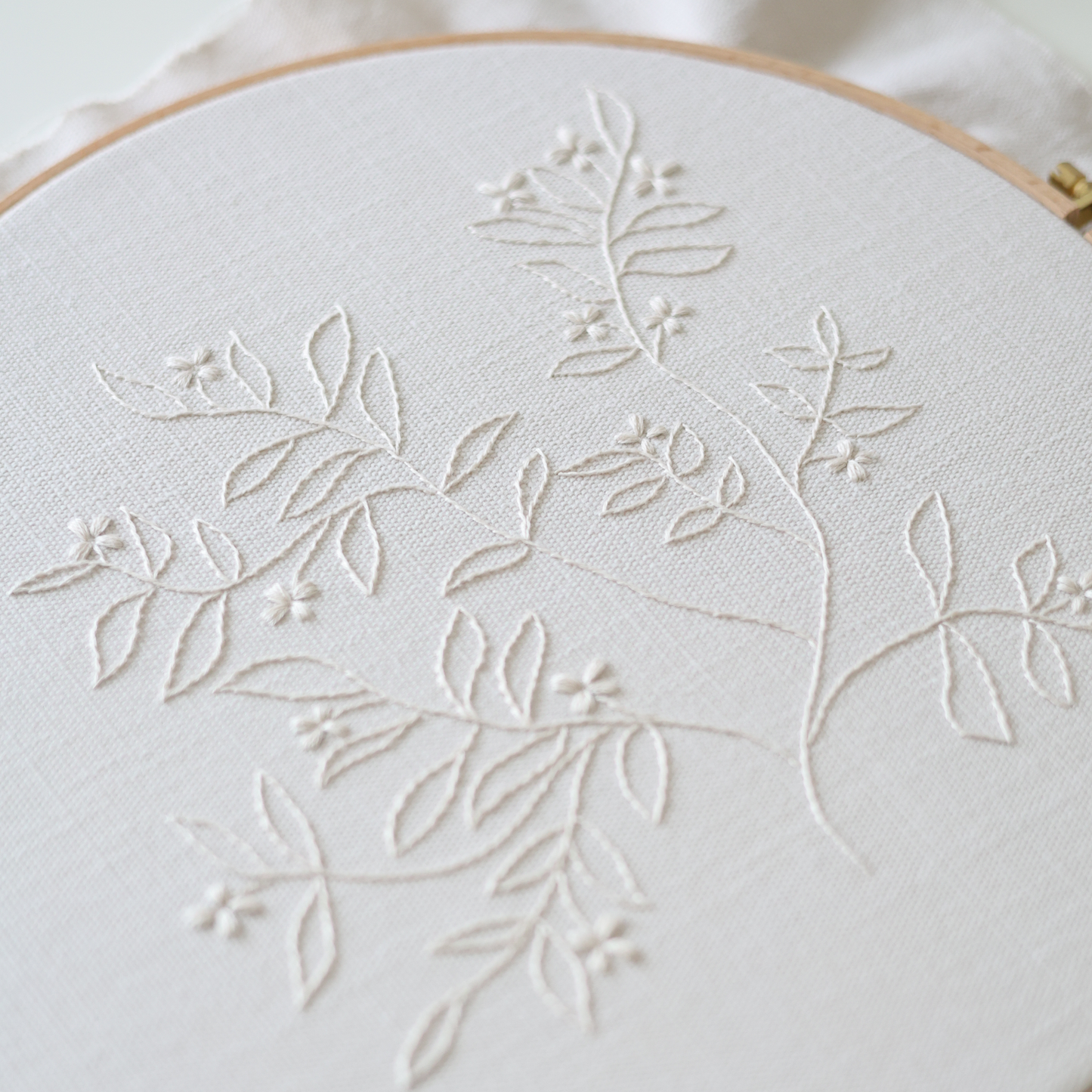 Side view of The Branch embroidery in wooden hoop