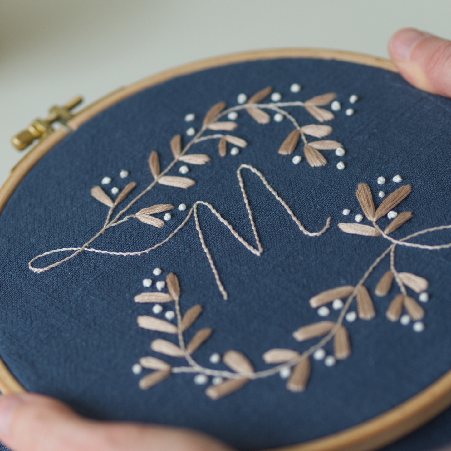 Embroidery hoop with floral design on a blue fabric