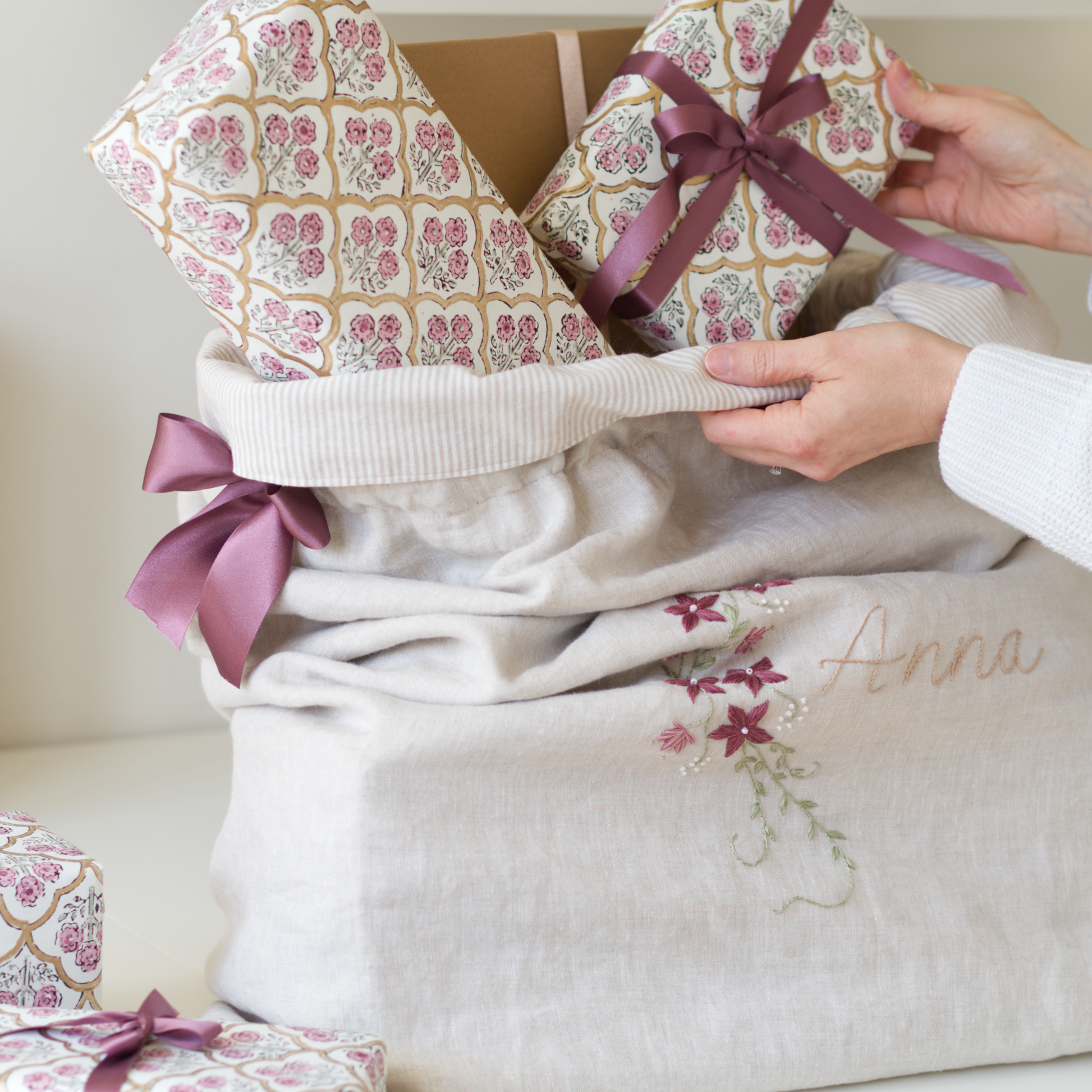 Christmas sack in beige linen, featuring a botanical embroidery design of a floral vine.